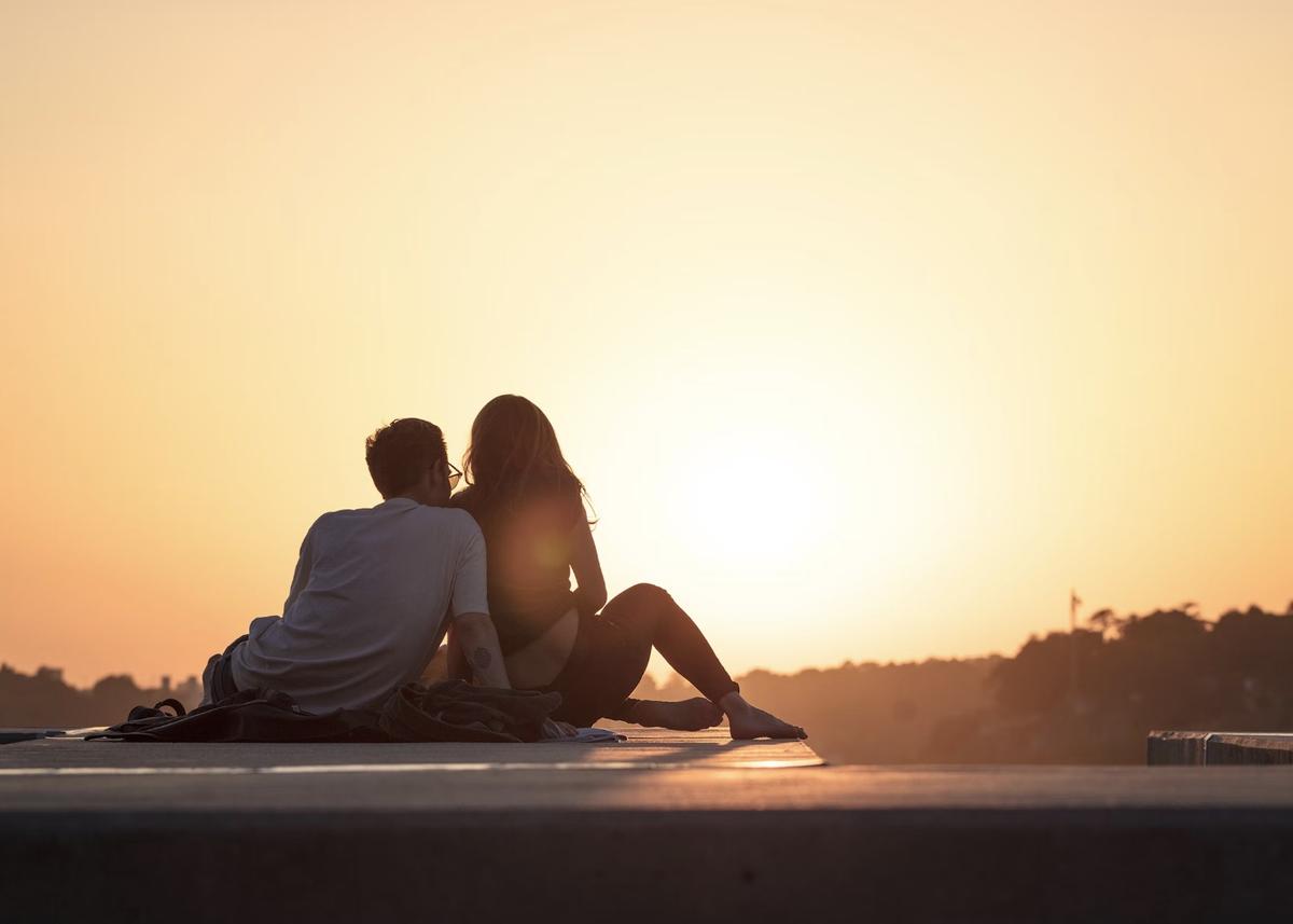 couple sitting near trees during golden hour